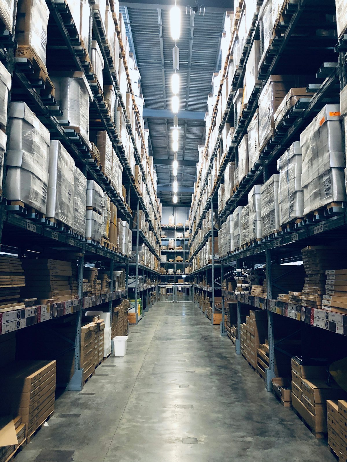 A long warehouse aisle with cartons stored on tall racks either side